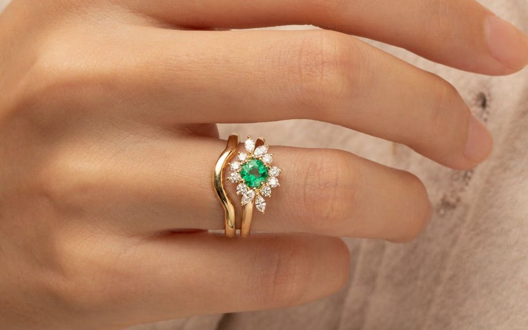 Emerald engagement ring worn with a notched yellow gold wedding band — Bonnot Paris
