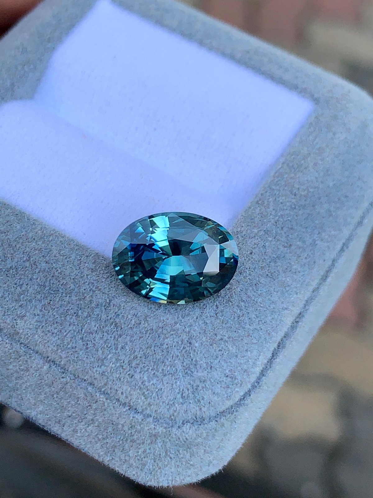 Saphir teal ovale présenté en boîte à pierre, avant sertissage — Bonnot Paris